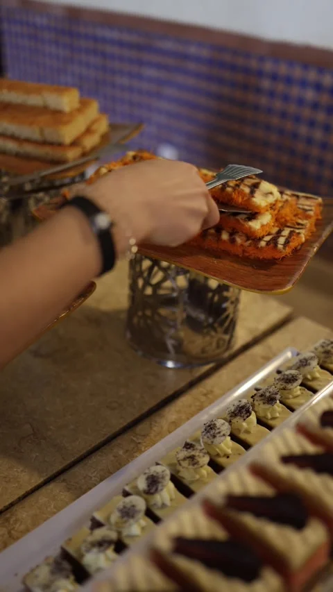 Vertical screen rich orange knafeh layered with cream and drizzled with syrup si Stock Footage 310013099