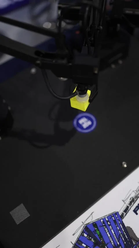 Vertical screen robotic manipulator places yellow cube near FEL ZCU logo precise Stock Footage 311130414