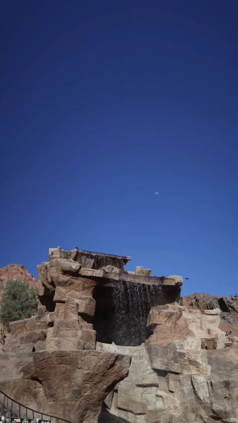 Vertical screen rocky desert waterfall cascades gently over sculpted stone under Stock Footage 310012569