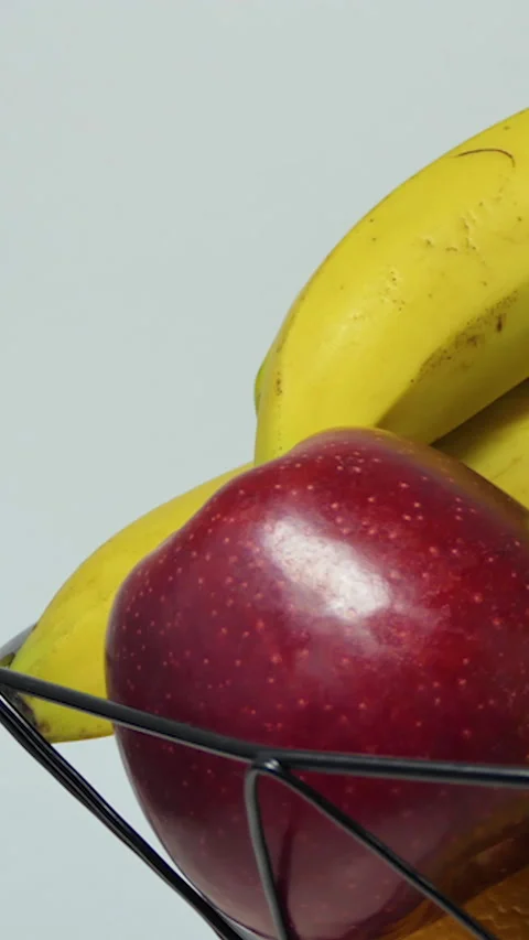Vertical Screen: Rotating fruit basket with fresh bananas, apple, orange and Stock Footage 231311466