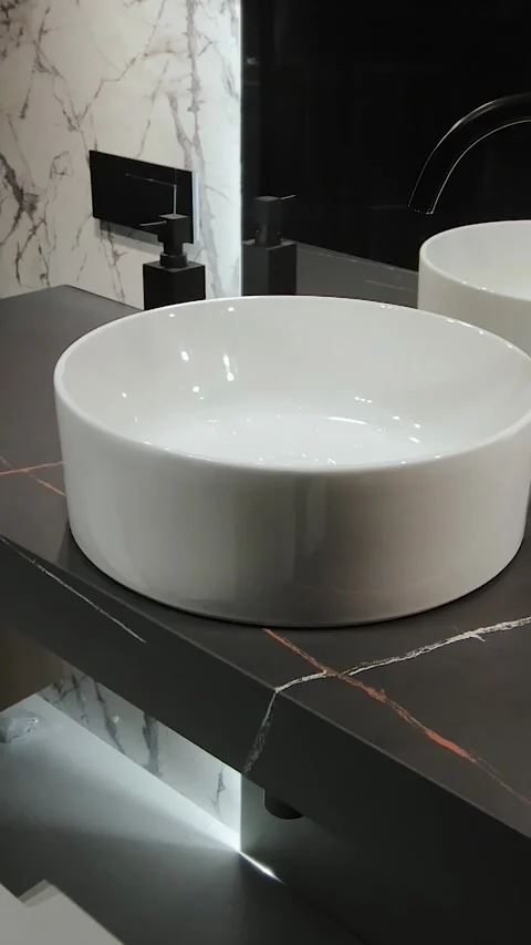 Vertical screen: The round bathroom sink with black faucet has an elegant Stock Footage 311253477