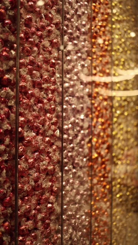 Vertical screen: Rows of colorful wrapped candies displayed in transparent conta Stock Footage 300162171