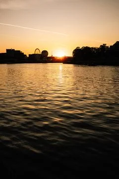 Vertical screen: shadowed riverside view with distant silhouette of Ferris wheel Stock Photos
