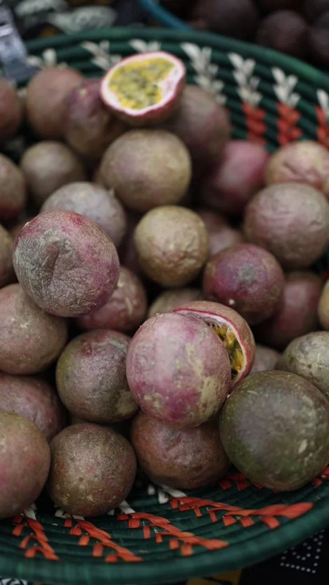 Vertical screen showing a close-up of passion fruits piled in a basket. One frui Stock Footage 303285929