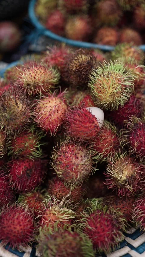 Vertical screen showing a close-up of rambutans, exotic spiky fruits, piled toge Stock Footage 303285959