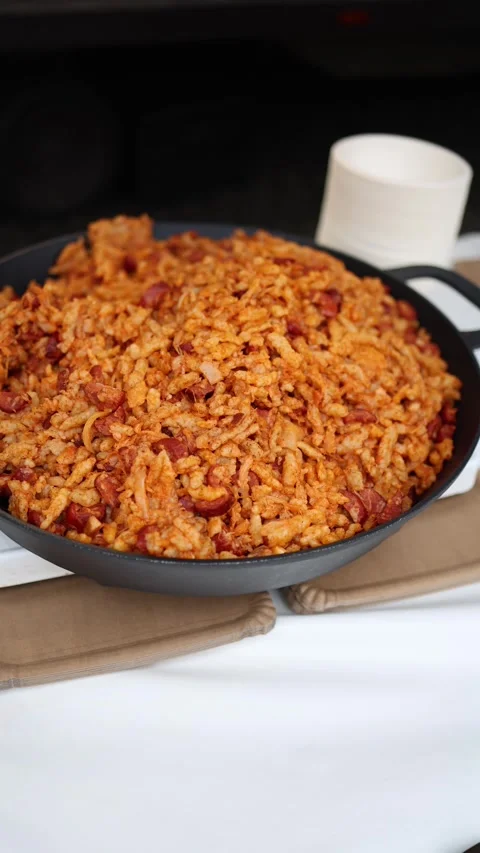 Vertical screen showing a large pan of fried rice with sausage pieces. The rice  Stock Footage 303285860