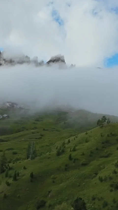 Vertical screen Silent mountains hide beneath clouds, Solitary trekker walks Stock Footage 323890924