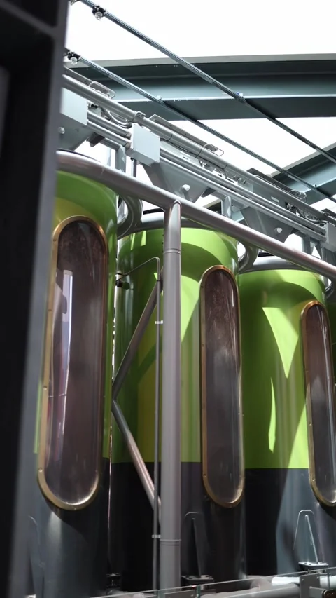 Vertical screen sleek green coffee silos connected by steel pipes inside modern  Stock Footage 310470270