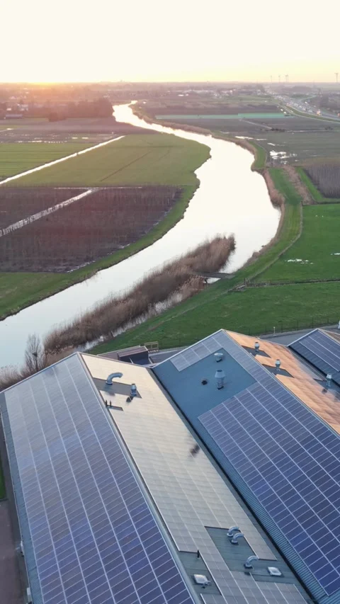 Vertical screen Solar Rooftop Overlooking Winding River Sunset, Drone Pans From Stock Footage 336703989