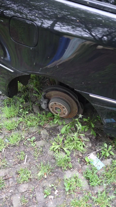 Vertical screen stolen car wheels abandoned vehicle resting on rusty brake disc  Stock Footage 307142536