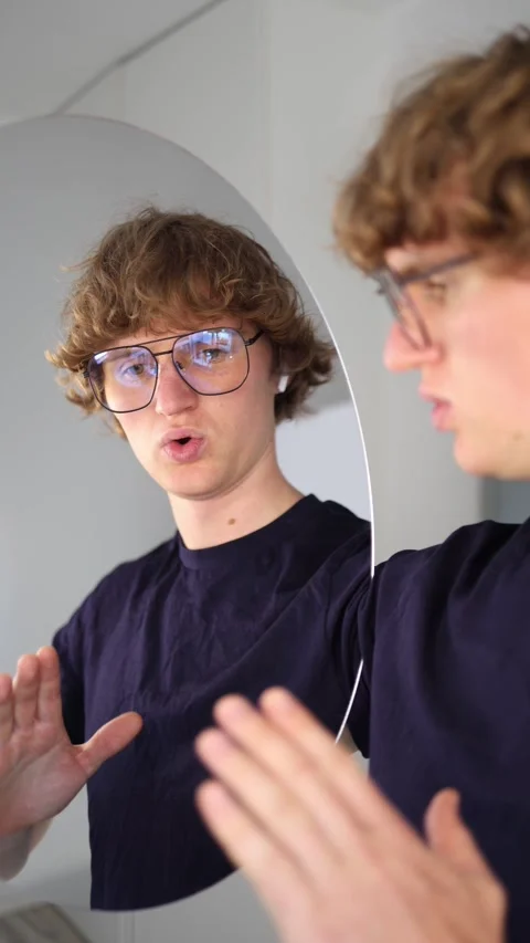 Vertical screen stressed man breathes deeply in front of the mirror trying to ca Stock Footage 313268776