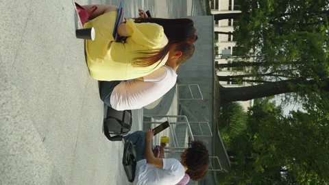Vertical Screen: Students relaxing after classes on stairs Stock Footage 247575778
