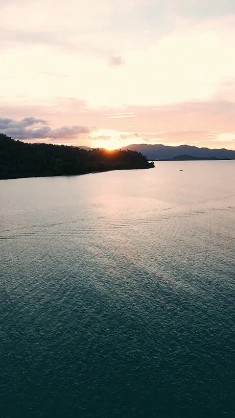 Vertical screen sun setting behind island over tropical sea in Palawan Stock Footage 318664306
