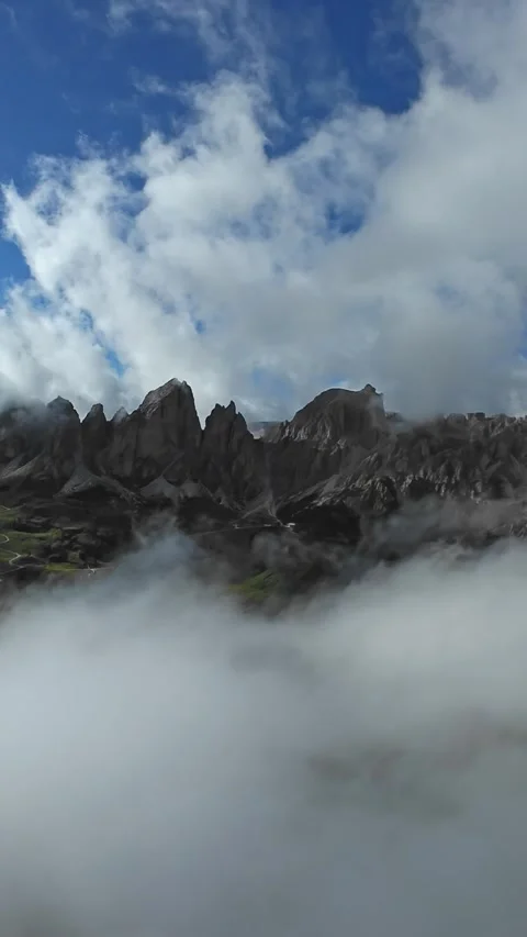 Vertical screen sunlit jagged ridge rising above low cloud inversion, painter Stock Footage 323575337