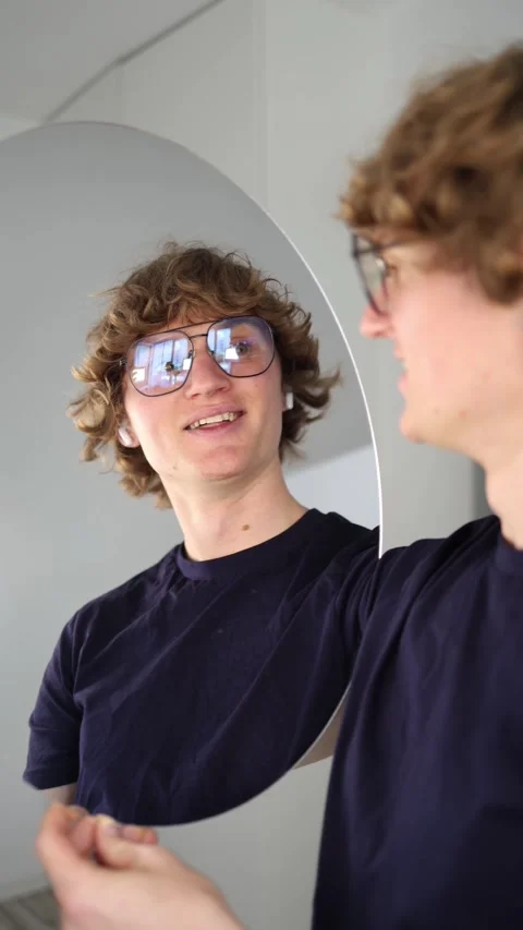 Vertical screen Surprised young man smiles with wide eyes while talking to his r Stock Footage 313268665
