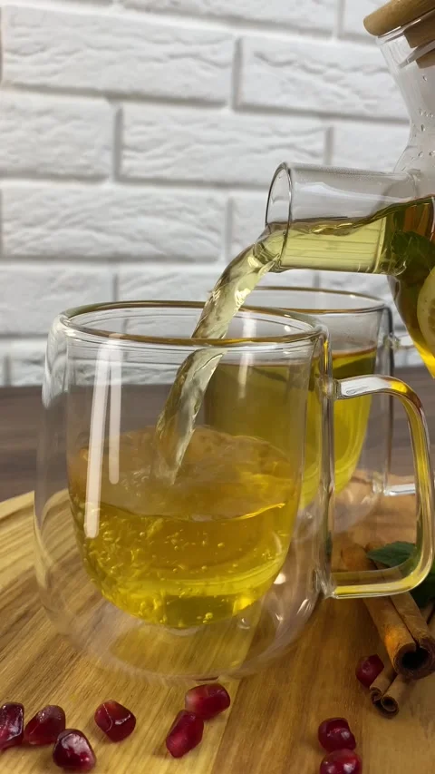 Vertical screen: Tea with herbs and berries is poured into a transparent tea cup Stock Footage 265900265