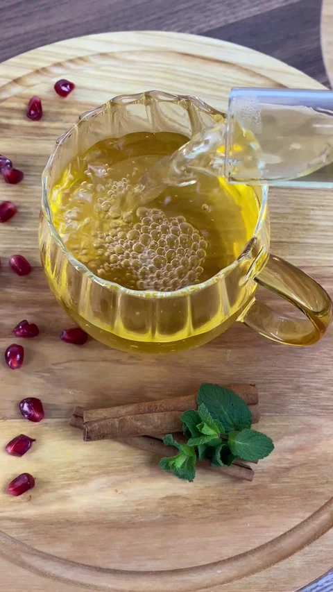 Vertical screen: Tea with herbs and berries is poured into a transparent tea cup Stock Footage 265900434