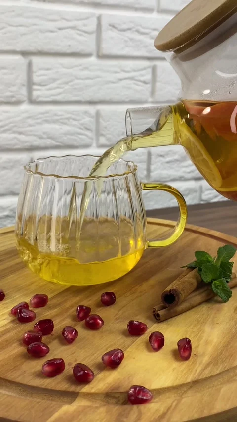 Vertical screen: Tea with herbs and berries is poured into a transparent tea cup Stock Footage 266149638