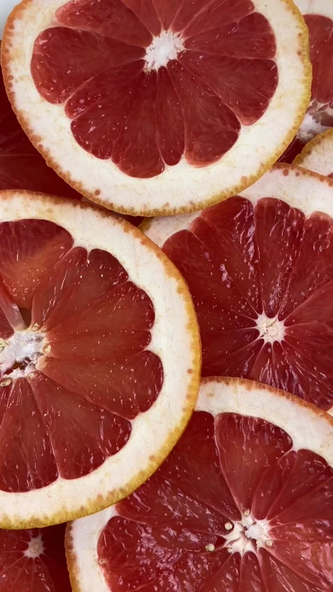 Vertical screen: Top view: many colorful fresh citrus grapefruit fruit slices on Stock Footage 265500470