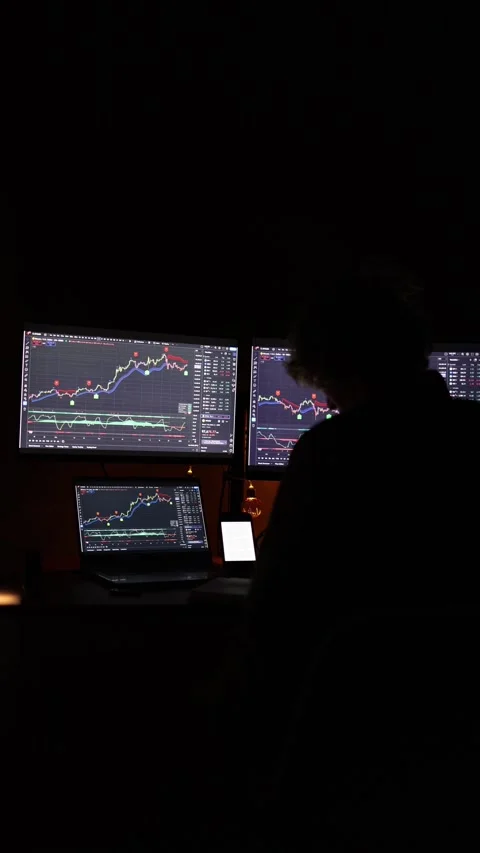 Vertical screen: A trader analyzing financial charts displayed on multiple monit Stock Footage 297110248