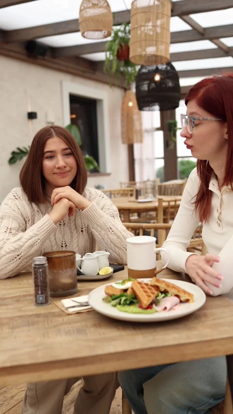 Vertical screen two cousins sit in a cafe Stock Footage 320827145