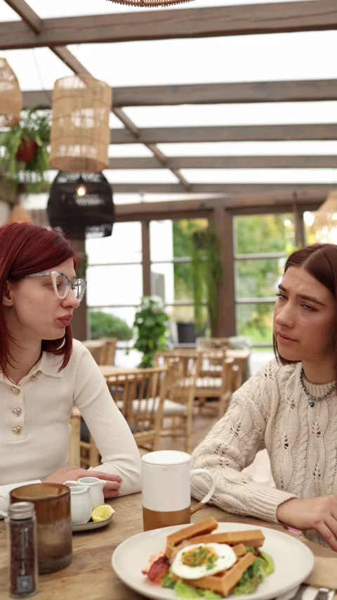 Vertical screen two friends sit in a quiet cafe  Stock Footage 320827183