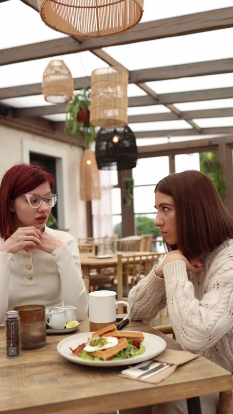 Vertical screen two friends sit in a cozy cafe Stock Footage 320827189