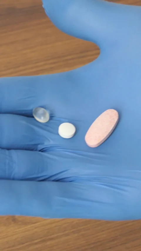 Vertical Screen: Two pills fall on a woman palm from bottle of pills. Close-up Stock Footage 232255485