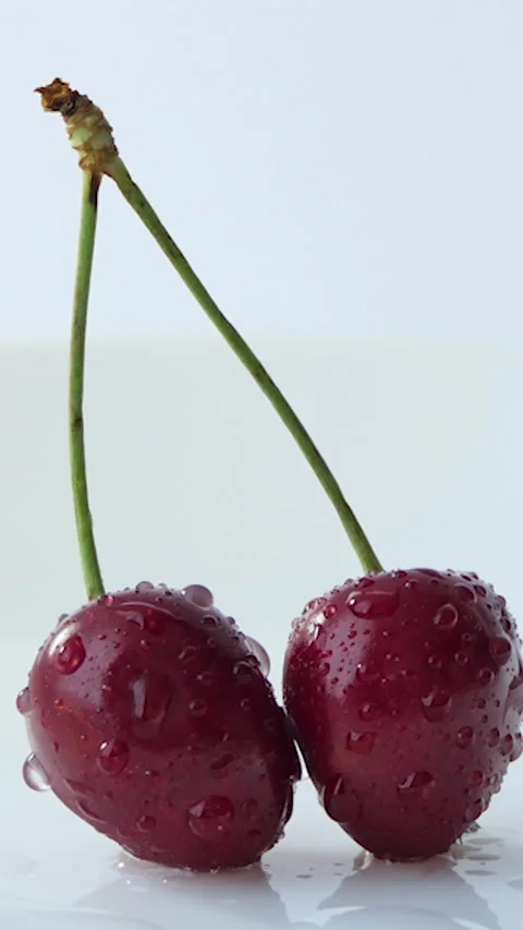 Vertical Screen: two red cherries on a white background. Cyclic movement Stock Footage 229966182