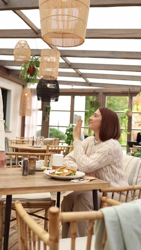 Vertical screen two sisters say goodbye in a cozy cafe  Stock Footage 320827192