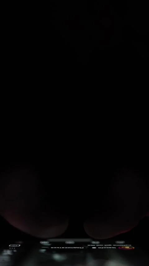 Vertical screen Two thumbs hover over glowing phone screen in darkness preparing Stock Footage 313842792