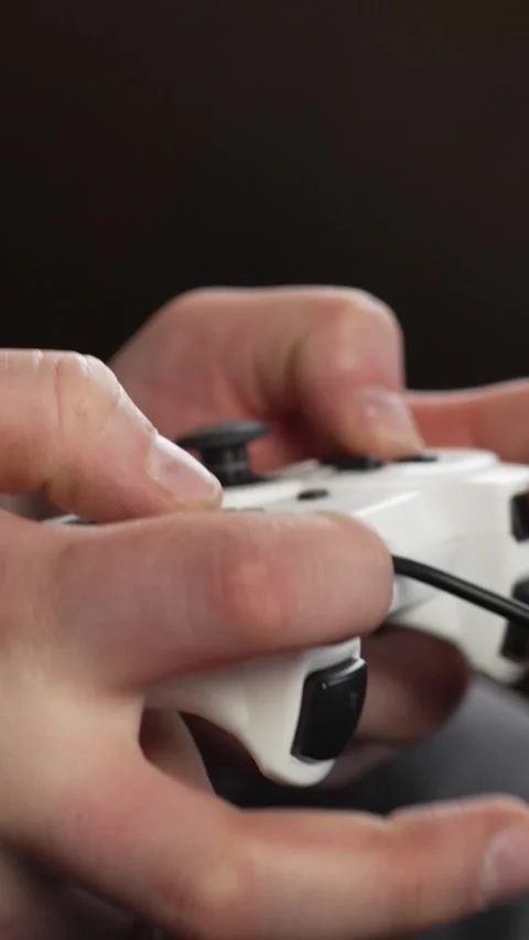 Vertical screen: Using controller playing video games - close up of hands and Stock Footage 263237208