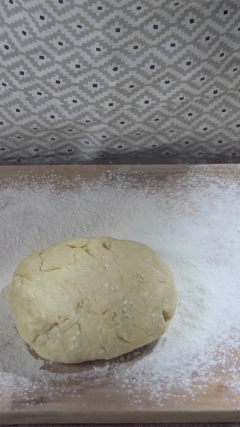 Vertical screen video. Dough Dropping into the Flour on the wooden kitchen board Stock Footage 299633072