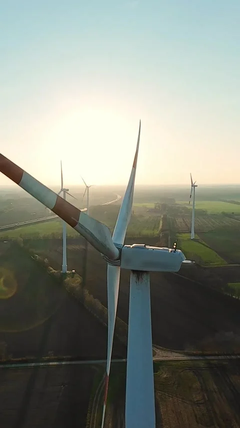 Vertical screen. Wind turbine facing the sun with symmetrical blades generating Stock Footage 325059710
