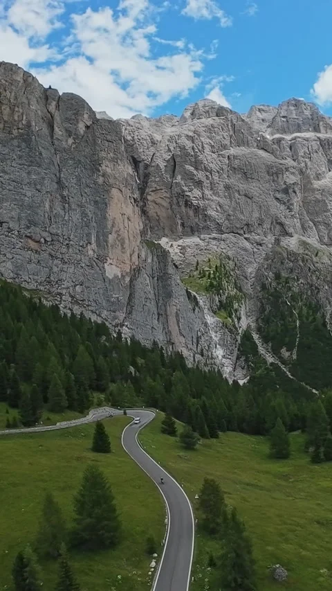 Vertical screen Winding Road Leading To Towering Cliffs, Lone Cars Crossing Video stock 330835147