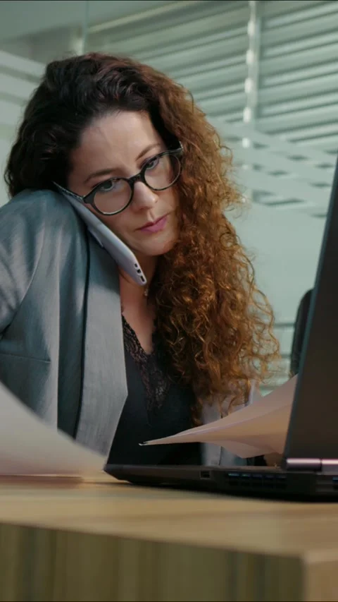 Vertical Screen Woman calling a key client in office giving details of the trade Stock Footage 299983807