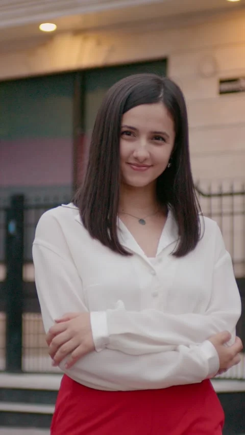 Vertical Screen woman posing on camera dressed in white blouse and red trousers. Stock Footage 299956244