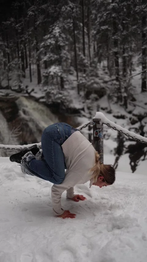Vertical screen: A woman practicing yoga in the snow with a powerful pose, surro Stock Footage 302794030