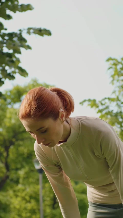 Vertical Screen Woman stops from jogging and making short break to breath. Stock Footage 299852730