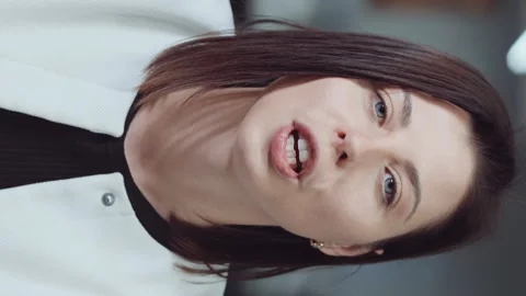 Vertical Screen: Woman talking to camera and sending air kiss in office Stock Footage 223755082