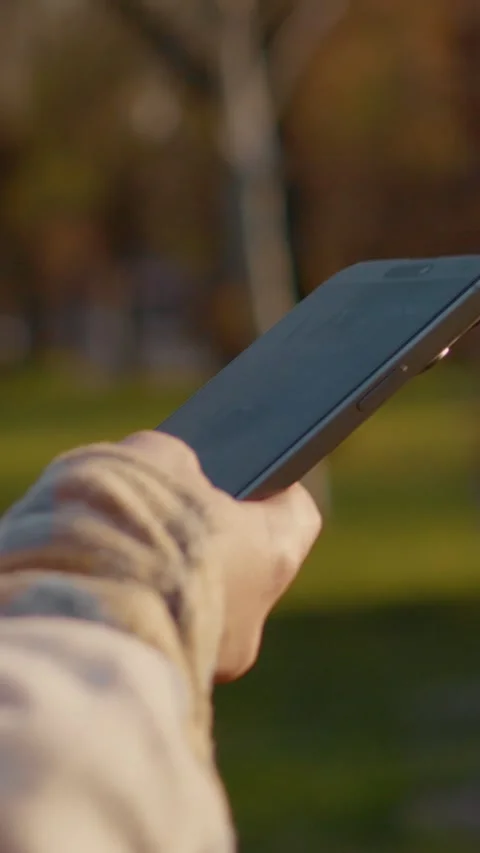 Vertical Screen Woman using smartphone in a park Stock Footage 303563622