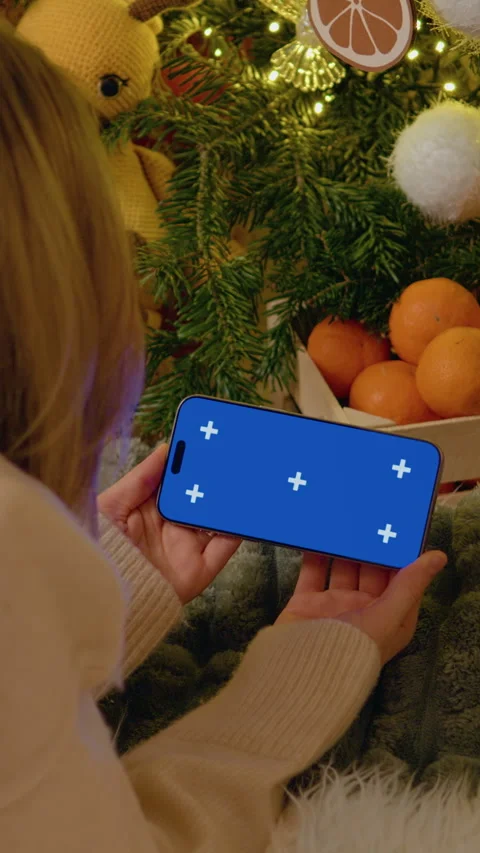 Vertical Screen Woman using Smartphone with Mockup near Christmas Tree Stock Footage 317976429