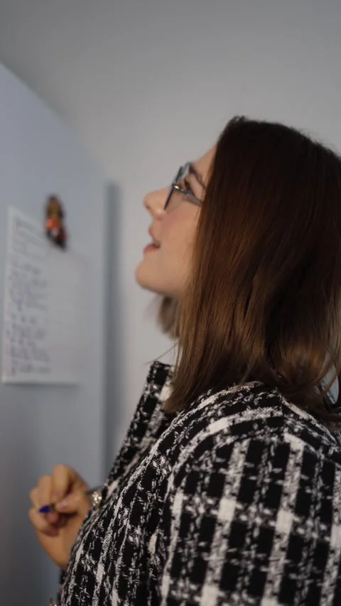 Vertical screen woman writes a task list on the fridge to organize her day Stock Footage 327217226