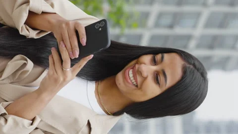 Vertical Screen: Young amiable black woman texting message and smiling Stock Footage 251635202