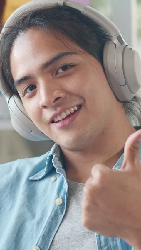 Vertical Screen : Young Asian designer man listening to music on headphones. Vídeo Stock 337022036