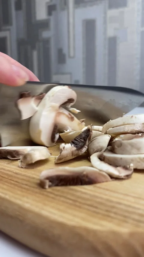 Vertical screen: The young chef in restaurant uniform works in the kitchen and Stock Footage 240873710