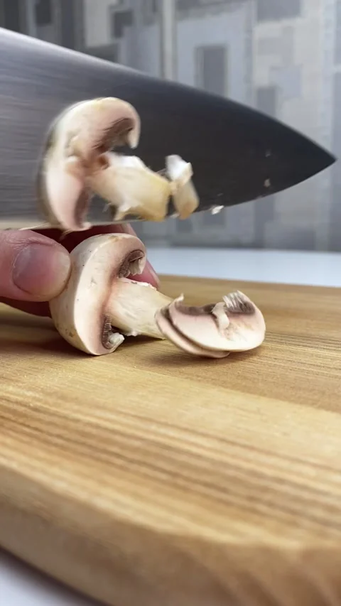 Vertical screen: The young chef in restaurant uniform works in the kitchen and Stock Footage 240873720