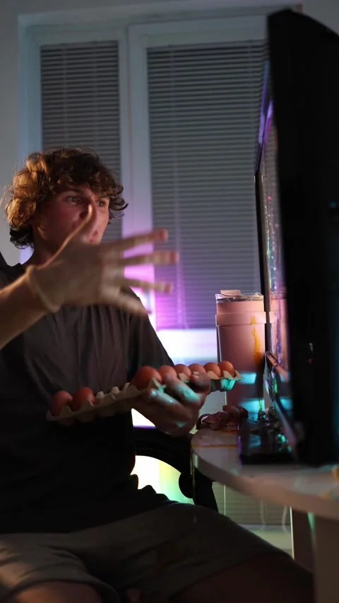 Vertical screen young man furiously throws eggs at monitor reacting Stock Footage 320820510