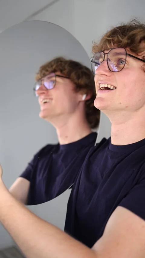 Vertical screen Young man laughs joyfully while raising his hands toward the mir Stock Footage 313268531