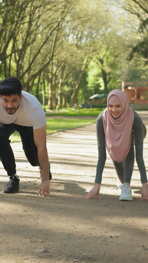 Vertical Screen: Young muslim couple in sport clothes standing in start position Stock Footage 274193914